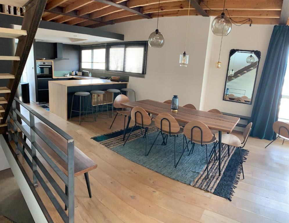 a dining room and kitchen with a wooden table and chairs at VILLA "Le LOFT" in Wimereux