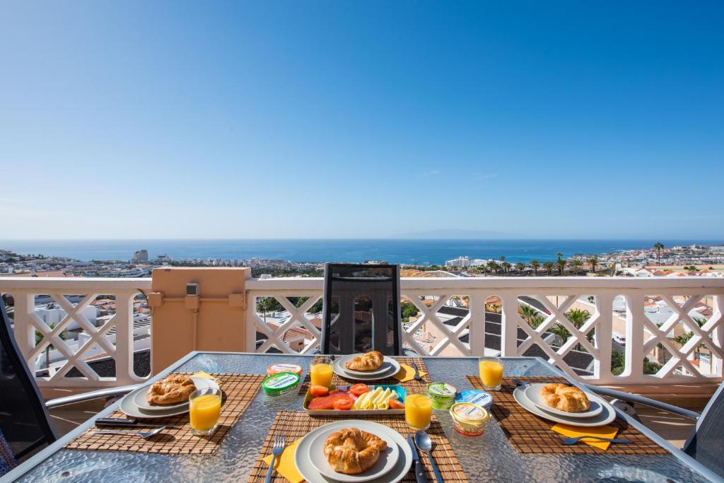een tafel met borden eten op het balkon bij 109 Penthouse , incredible view, Marco in Adeje