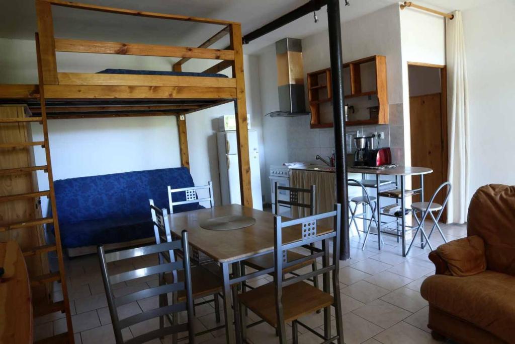 a room with a dining table and a bunk bed at Ferme Equestre Les Coccinelles in Lurs