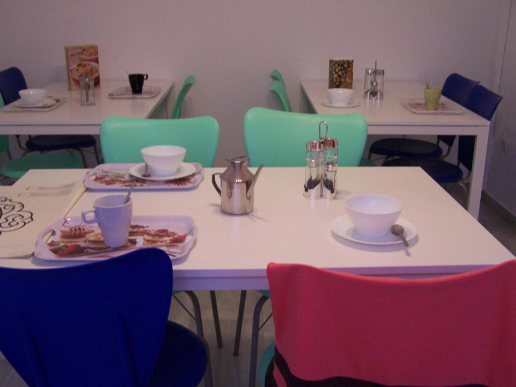 una mesa con sillas y platos de comida. en Granada Old Town Hostel, en Granada