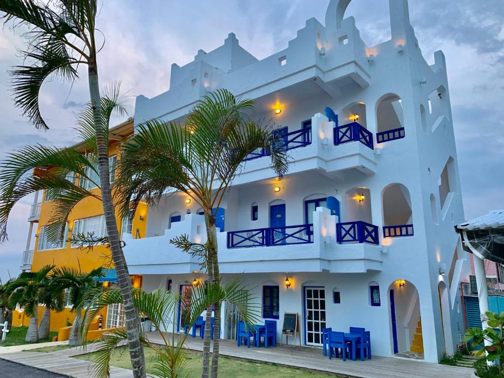 un edificio bianco con palme di fronte di Canaan B&B Kenting a Eluan