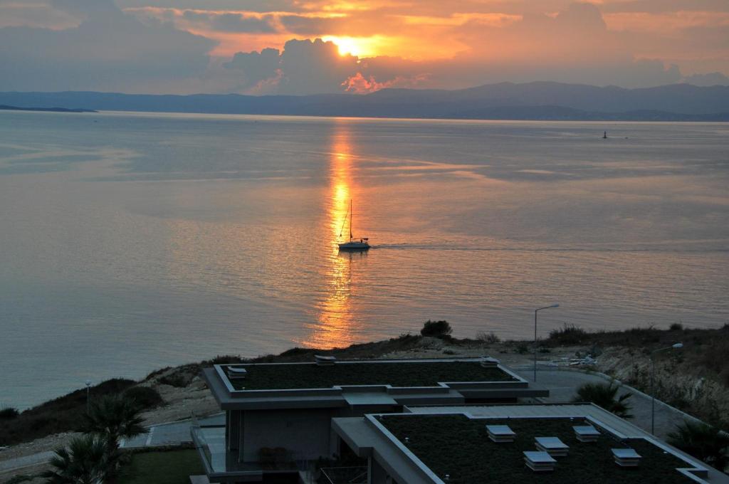 a boat in the water with a sunset in the background at Sato Design Hotel in Çeşme