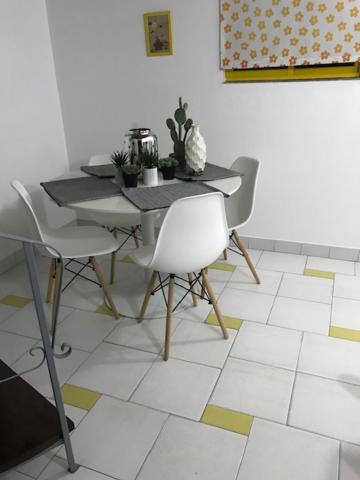 a dining room with a table and chairs on a tiled floor at Apartamentos Cavaco in Odeceixe