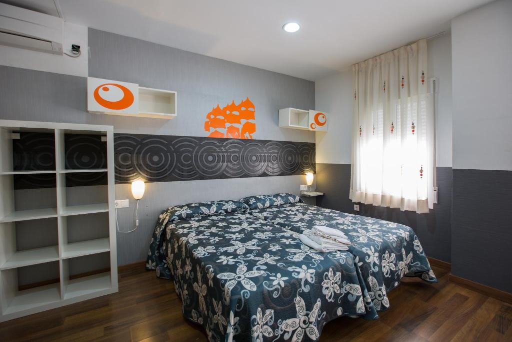 - une chambre avec un lit doté d'un couvre-lit bleu et blanc dans l'établissement Hostal Gaudi Cuenca, à Cuenca