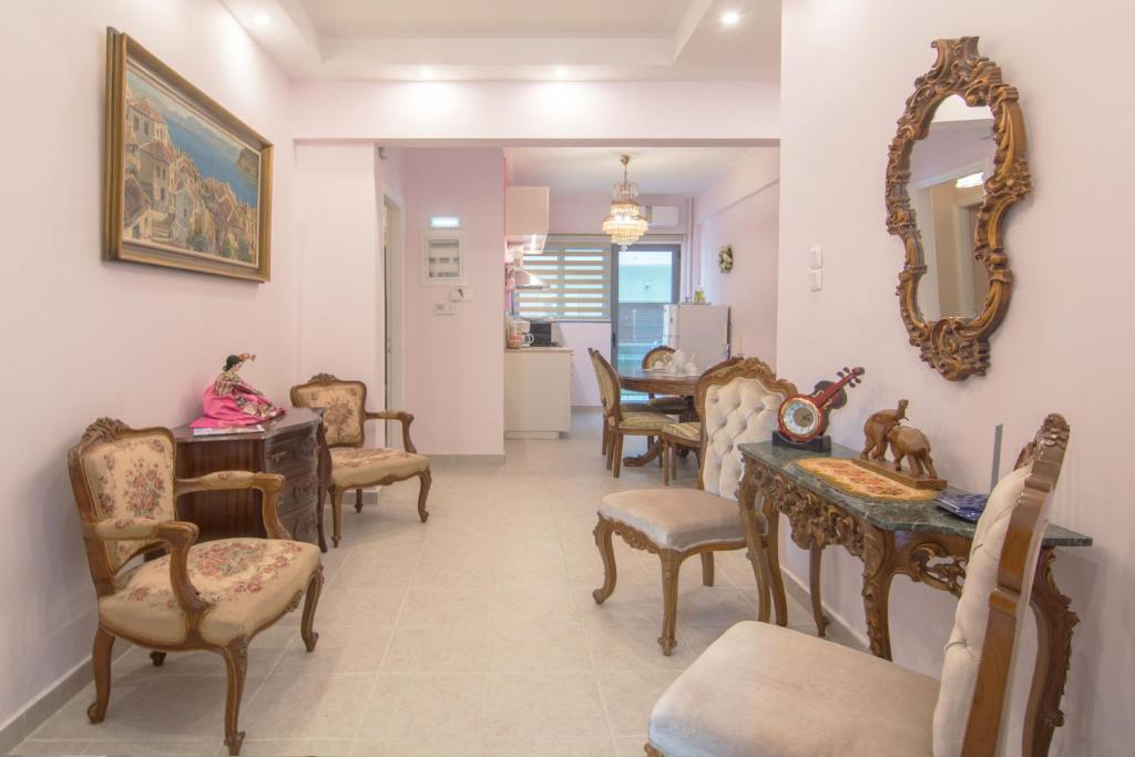 sala de estar con sillas, mesa y espejo en Lovely Apartment in Athens, en Atenas