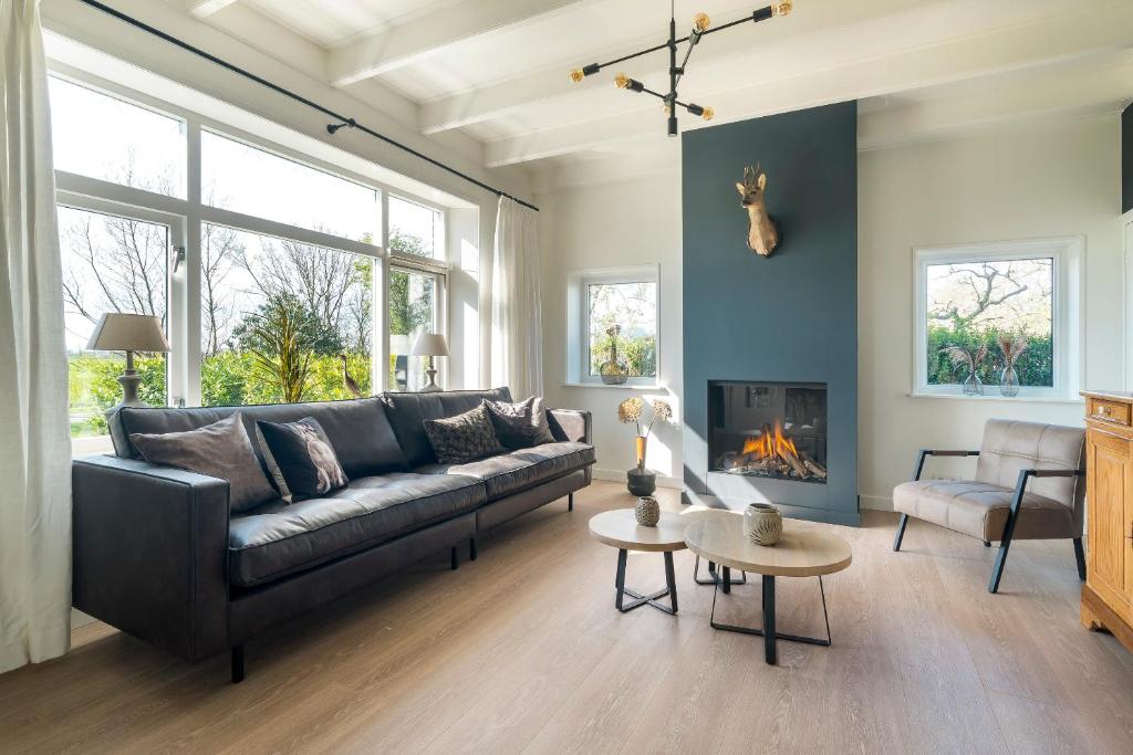 a living room with a couch and a fireplace at Boerderijwoning in Serooskerke