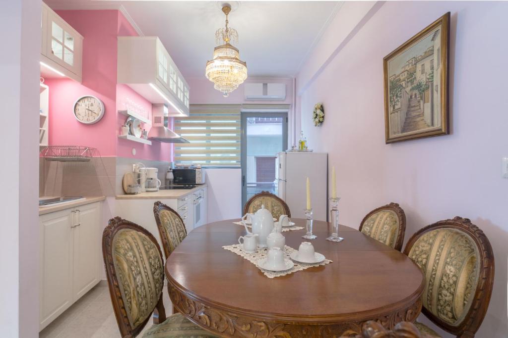 Una cocina y un comedor con mesa y sillas de madera. en Lovely Apartment in Athens, en Atenas