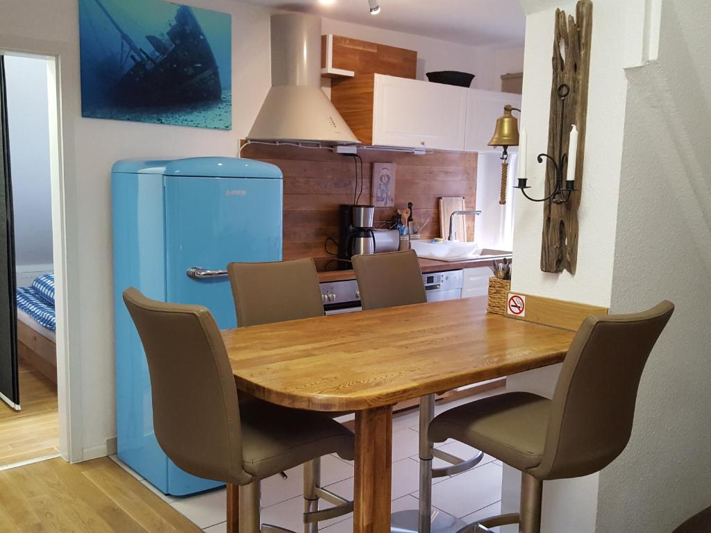a kitchen with a wooden table and a blue refrigerator at Apartments Harmsstraße 13 in Kiel