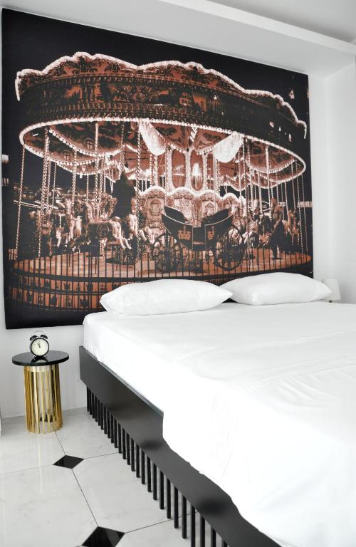 a bedroom with a bed and a poster of a carousel at Sato Design Hotel in Çeşme