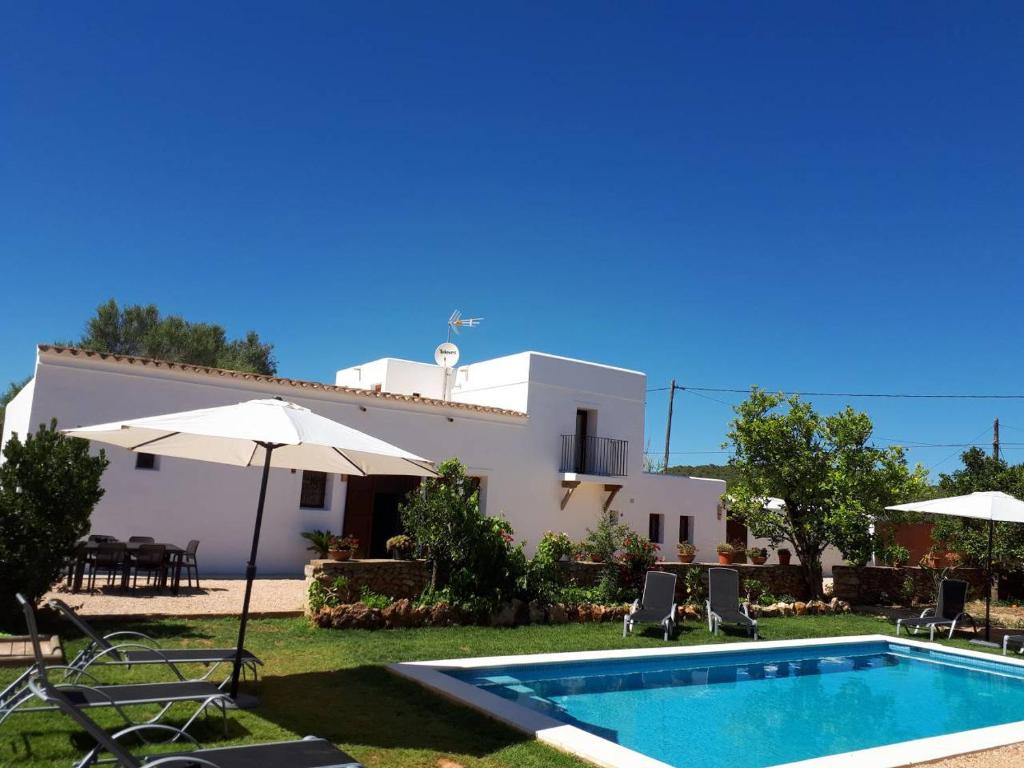 a villa with a swimming pool in front of a house at Casa Can Boletar in Santa Gertrudis de Fruitera