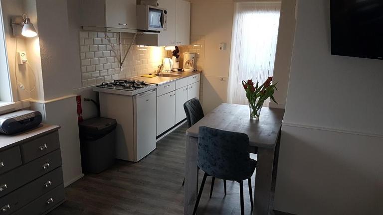 a kitchen with a table and chairs and a kitchen with a stove at Vakantiewoning met terras vlakbij strand en centrum in Zoutelande