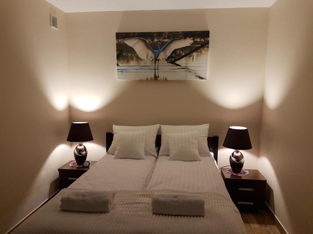 - une chambre avec un grand lit et deux lampes dans l'établissement Apartamenty Avanti-Stare Miasto Zamość, à Zamość