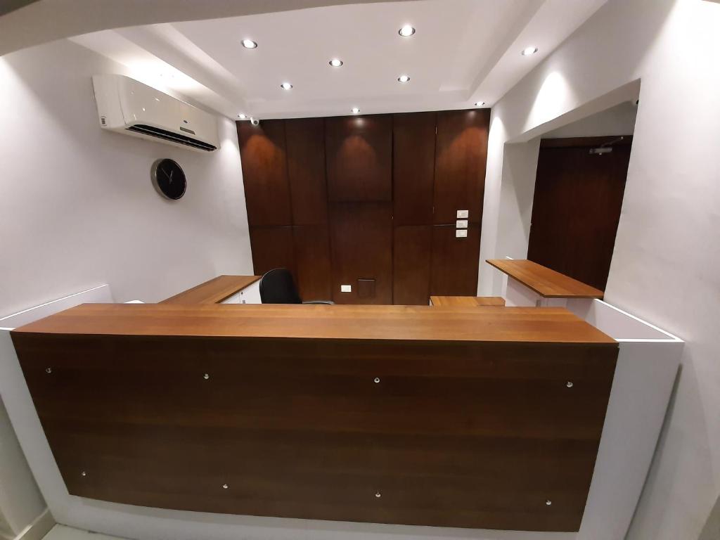 una oficina con escritorio de madera y espejo en Nakhil Inn Residence en El Cairo