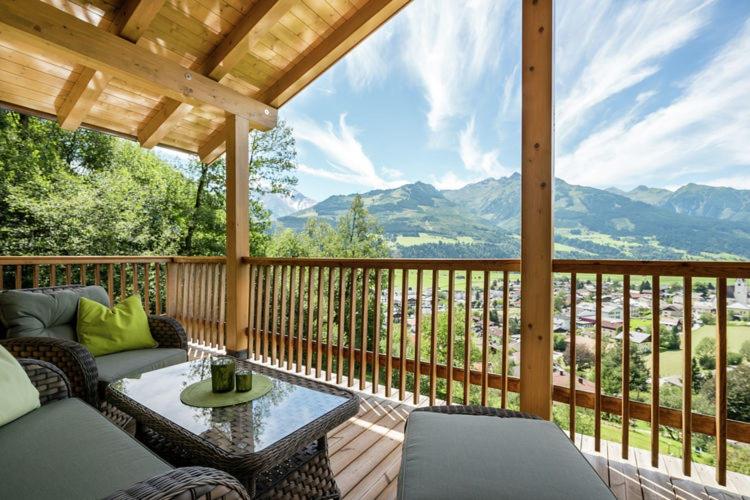 weranda z kanapą i stołem na pokładzie w obiekcie alpin penthouse w mieście Piesendorf