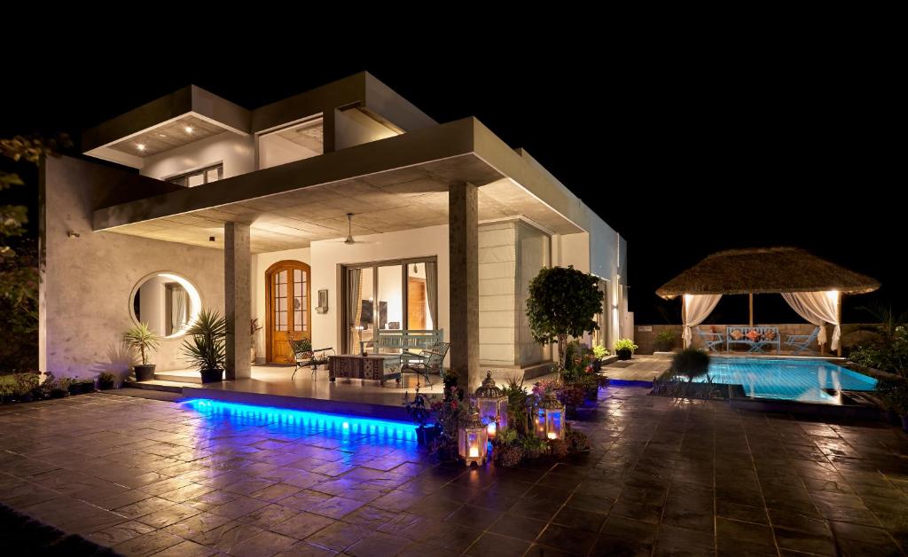 a villa with a swimming pool at night at Manna Villa in Mahabalipuram