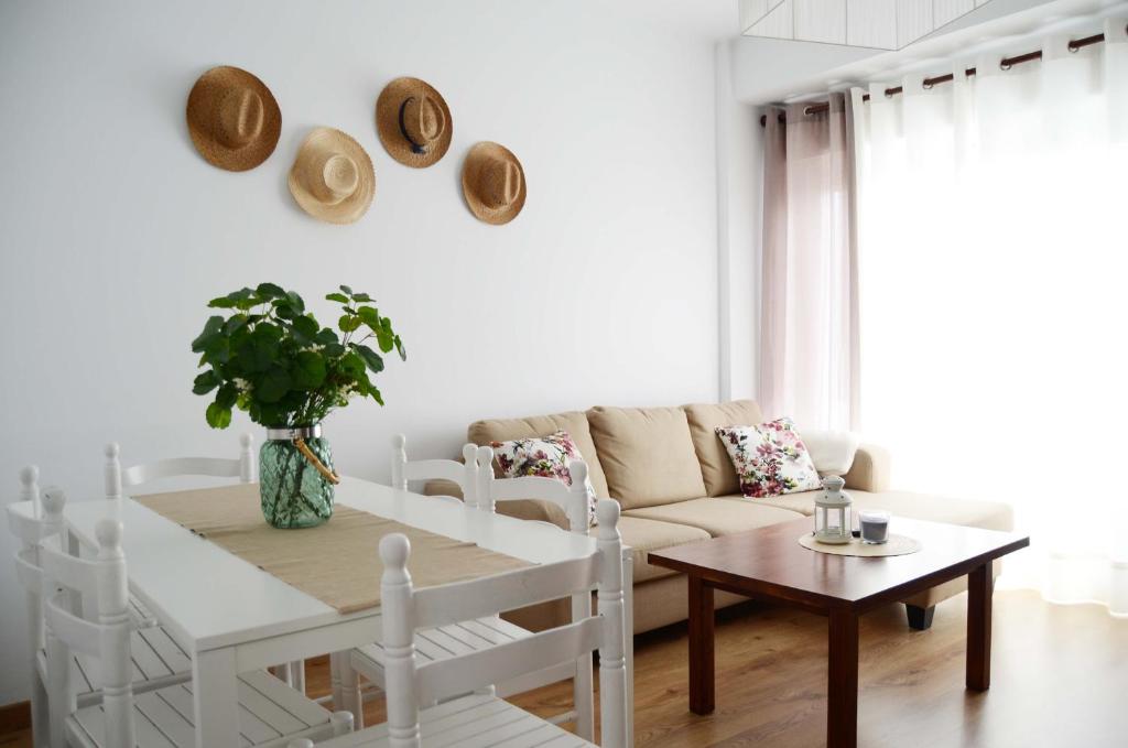 Biały salon z kanapą i stołem w obiekcie Apartamento Ana w mieście Portonovo