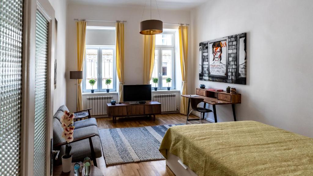 a bedroom with a bed and a desk and a television at Boutique Prater Apartments Vienna in Vienna