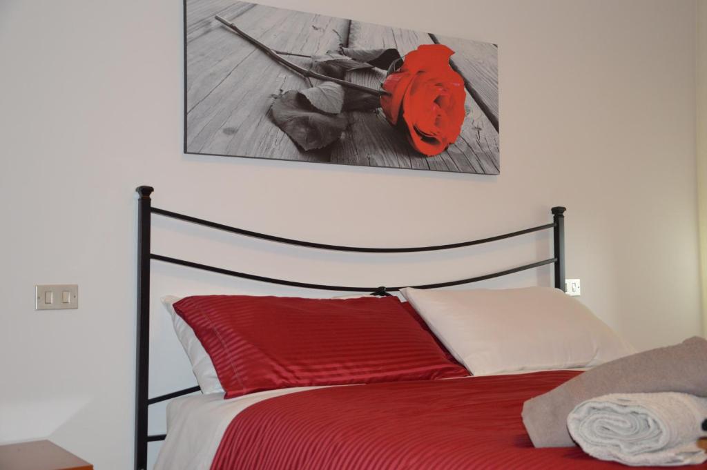 een slaapkamer met een rood bed en een schilderij aan de muur bij Casa di Giulia in Perugia