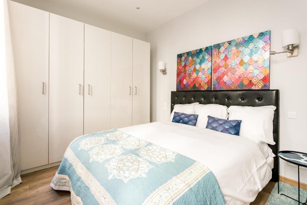 a bedroom with a large bed and a painting on the wall at Marais Saint Paul Ecouffes in Paris