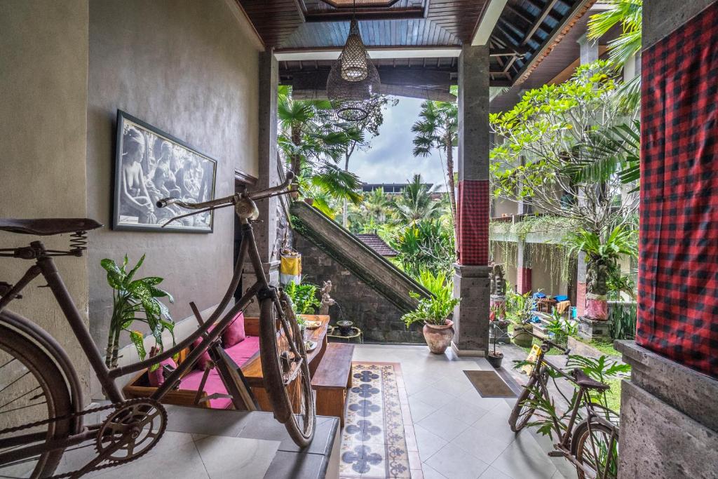 a bicycle parked in a room with plants at Alam Terrace Cottages in Ubud
