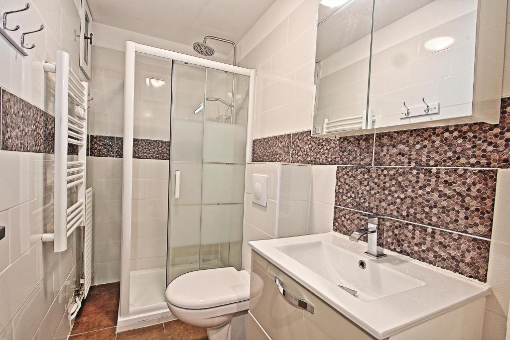 a white bathroom with a toilet and a sink at Appartements résidence Roches Rouges in Tignes