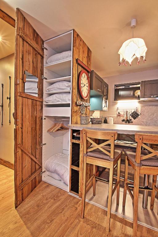 a kitchen with a table and a clock in a room at Appartements résidence Roches Rouges in Tignes