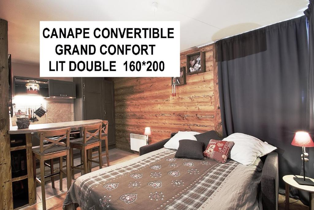 a bedroom with a bed and a table with a bar at Appartements résidence Roches Rouges in Tignes