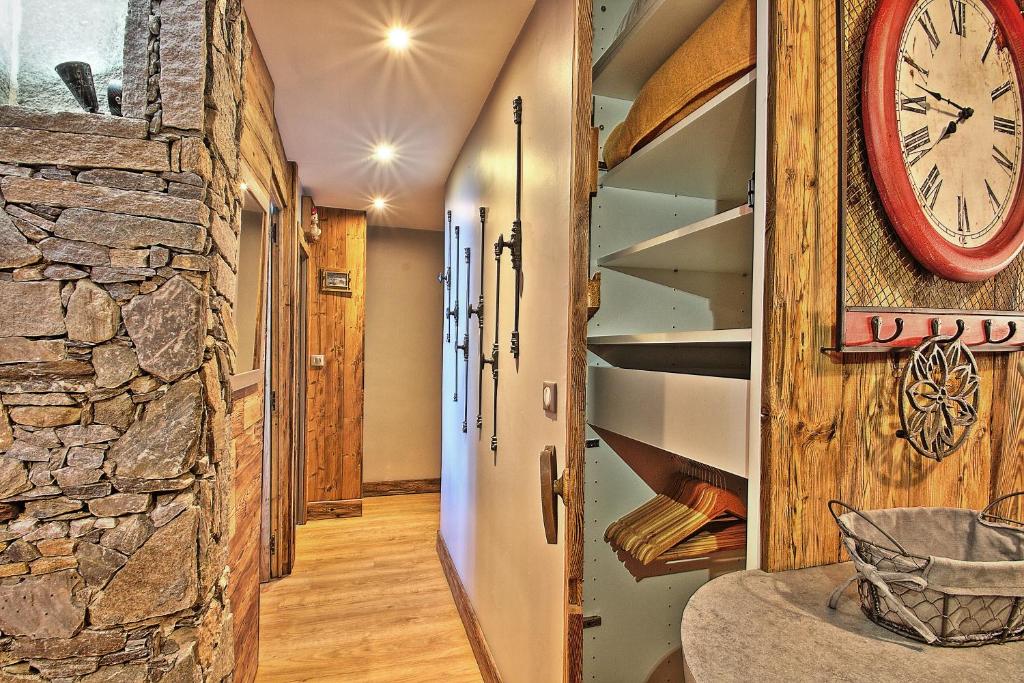 a room with a clock on the wall and a staircase at Appartements résidence Roches Rouges in Tignes