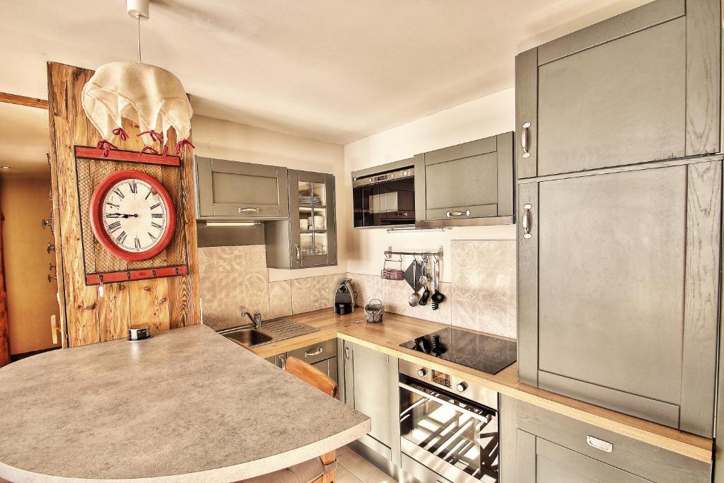 a kitchen with a large clock on the wall at Appartements résidence Roches Rouges in Tignes