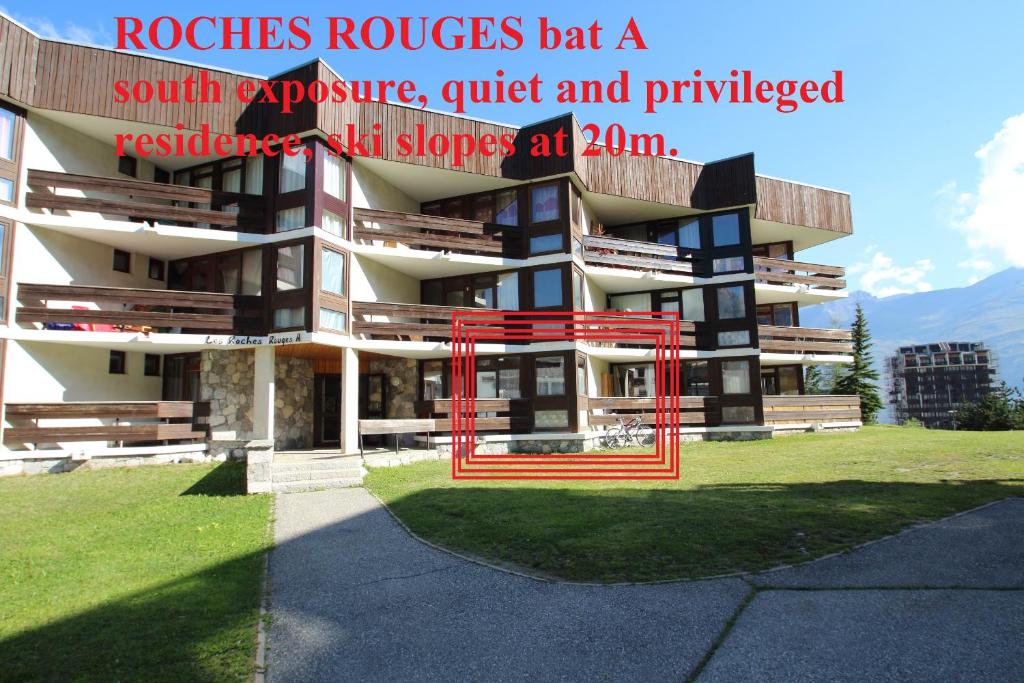 a building with a red gate in front of it at Appartements résidence Roches Rouges in Tignes