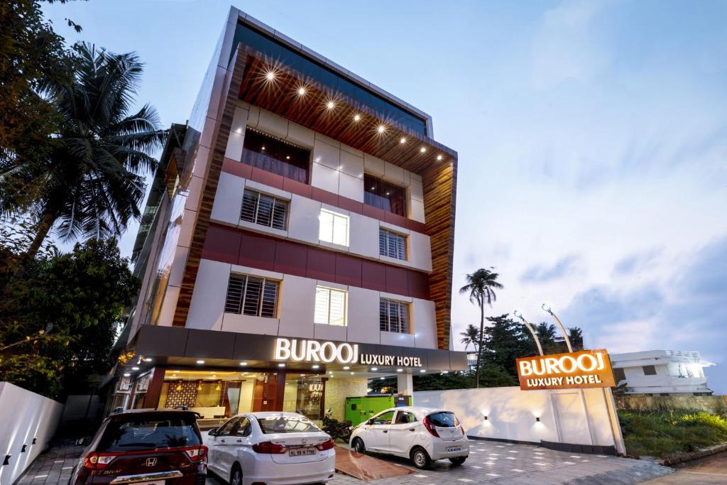 two cars parked in front of a building at Burooj Hotel in Cochin