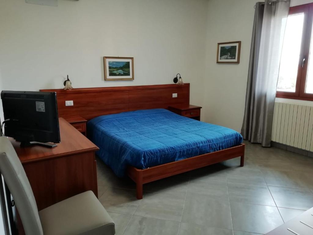 Schlafzimmer mit einem Bett und einem Schreibtisch mit einem Computer in der Unterkunft B&B Tequila in Olbia