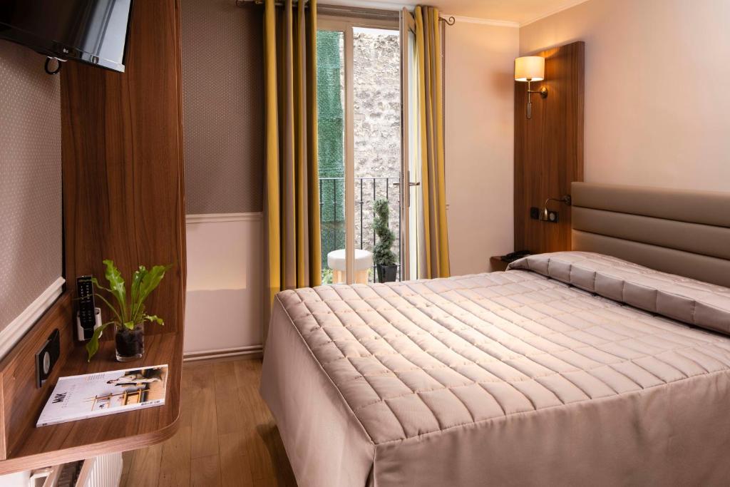une chambre d'hôtel avec un lit et une fenêtre dans l'établissement Hôtel de la Tour Eiffel, à Paris
