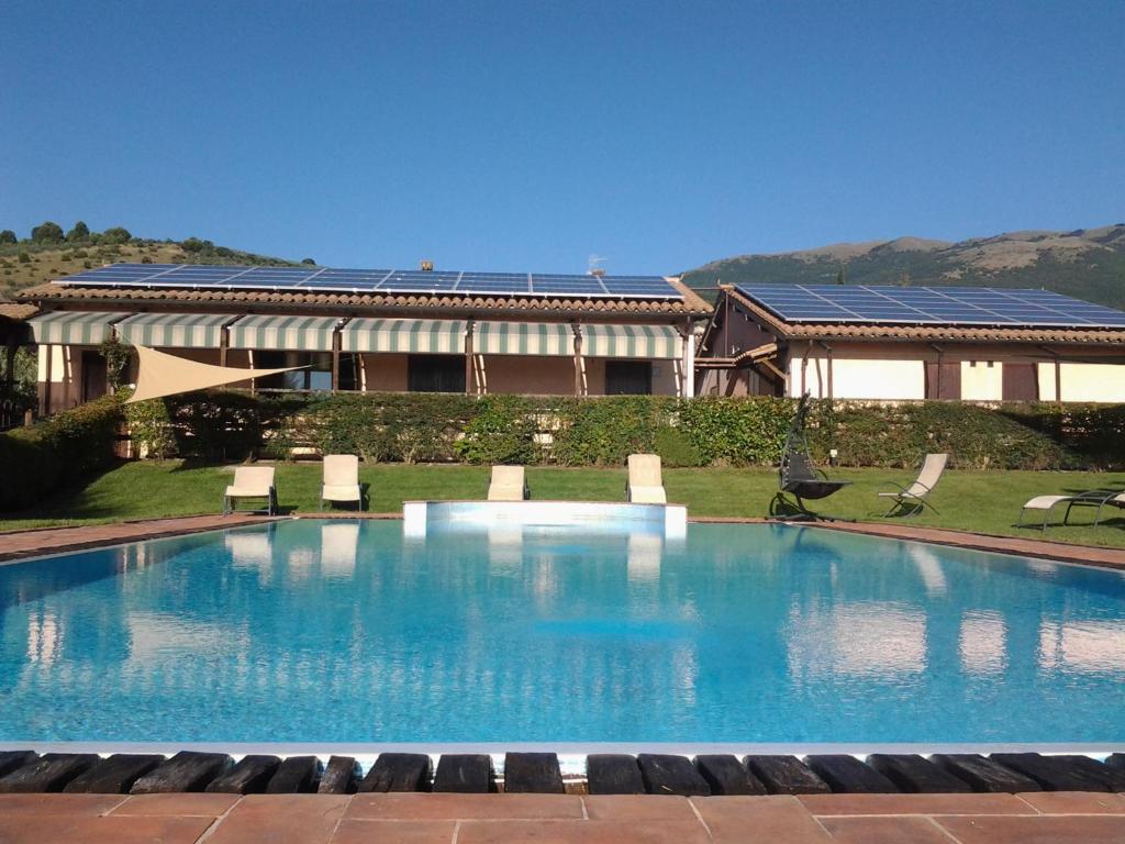 a large swimming pool in front of a house at Il Borgo Dell'Ulivo in Trevi