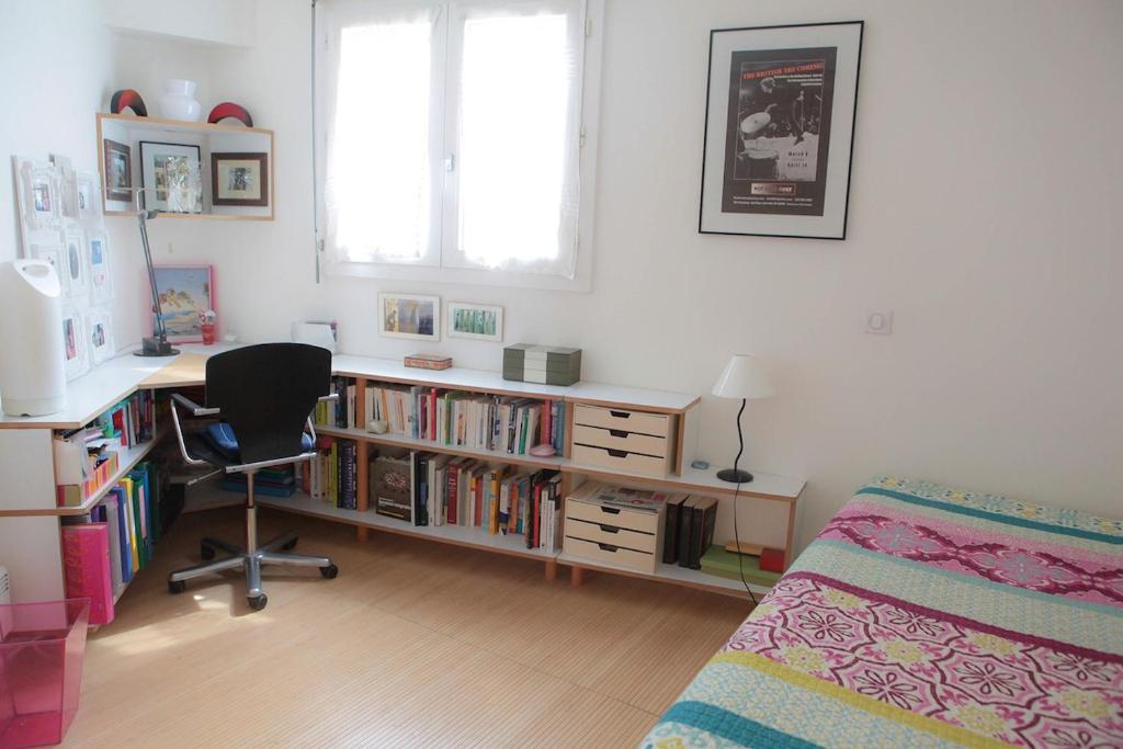 a bedroom with a desk and a bed and a book shelf with books at Apartment with terrace 5 people Bastille by Weekome in Paris