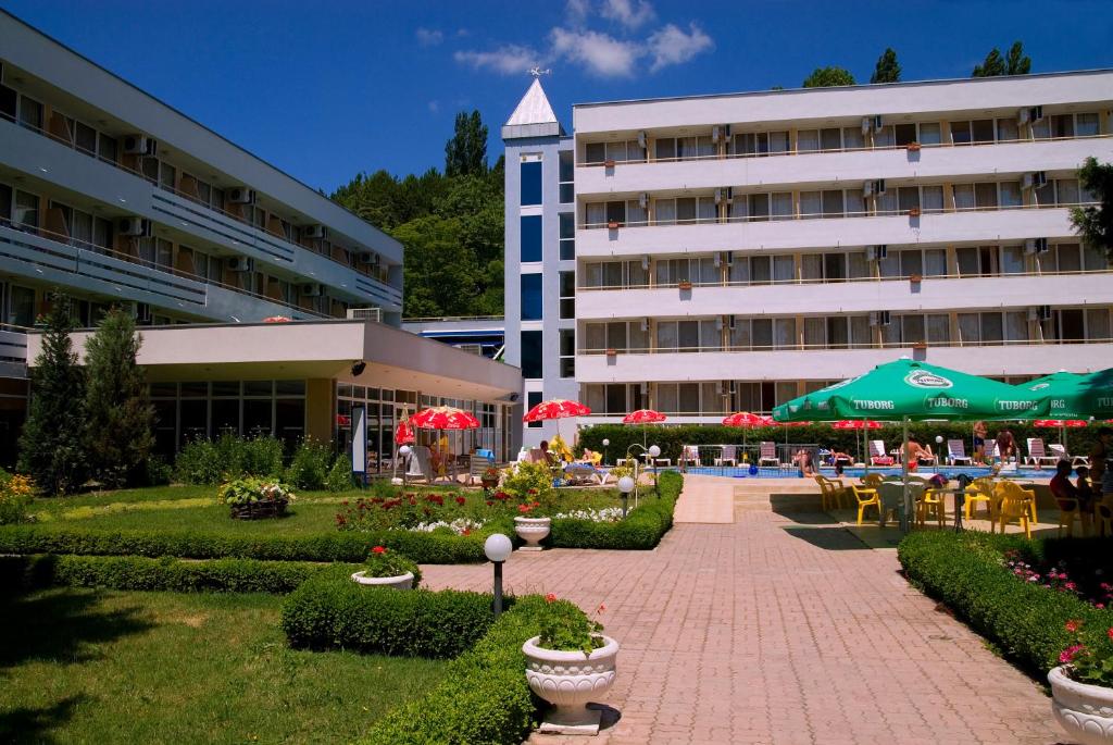 a hotel with tables and chairs and a building at Hotel Oasis in Albena