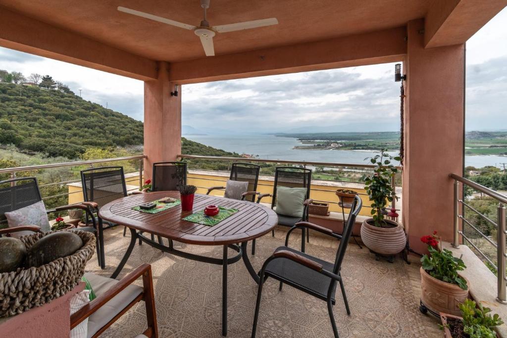 a balcony with a table and chairs and a view of the water at Villa Neraida in Neráïdha