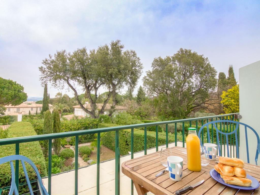 a wooden table with a plate of food on a balcony at Apartment Les Carles by Interhome in Saint-Tropez