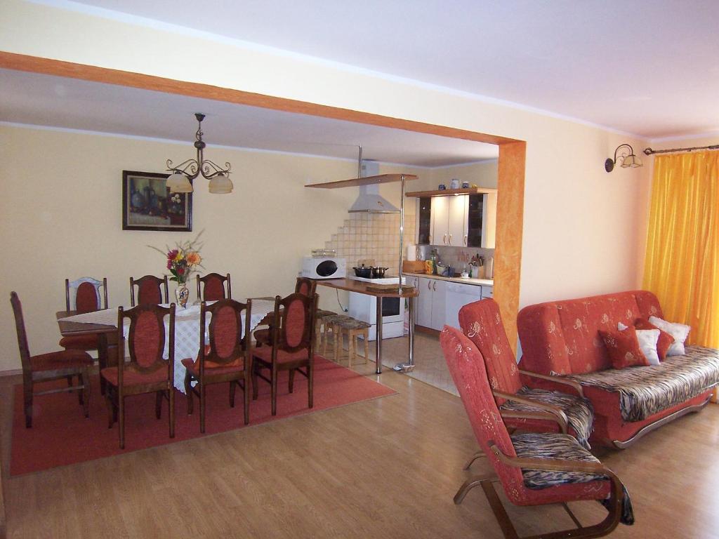 a living room with a table and chairs and a kitchen at Holiday Home Mielno 2 by Interhome in Mielno