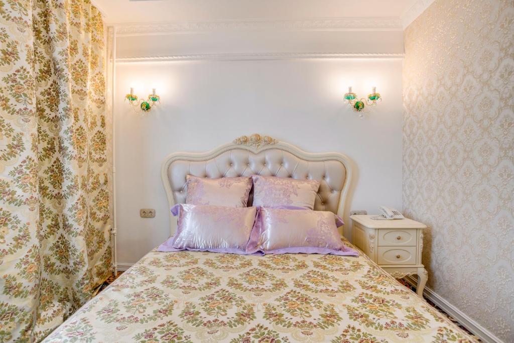 モスクワにあるGolden Hotelのベッドルーム1室(紫とピンクの枕が備わるベッド1台付)