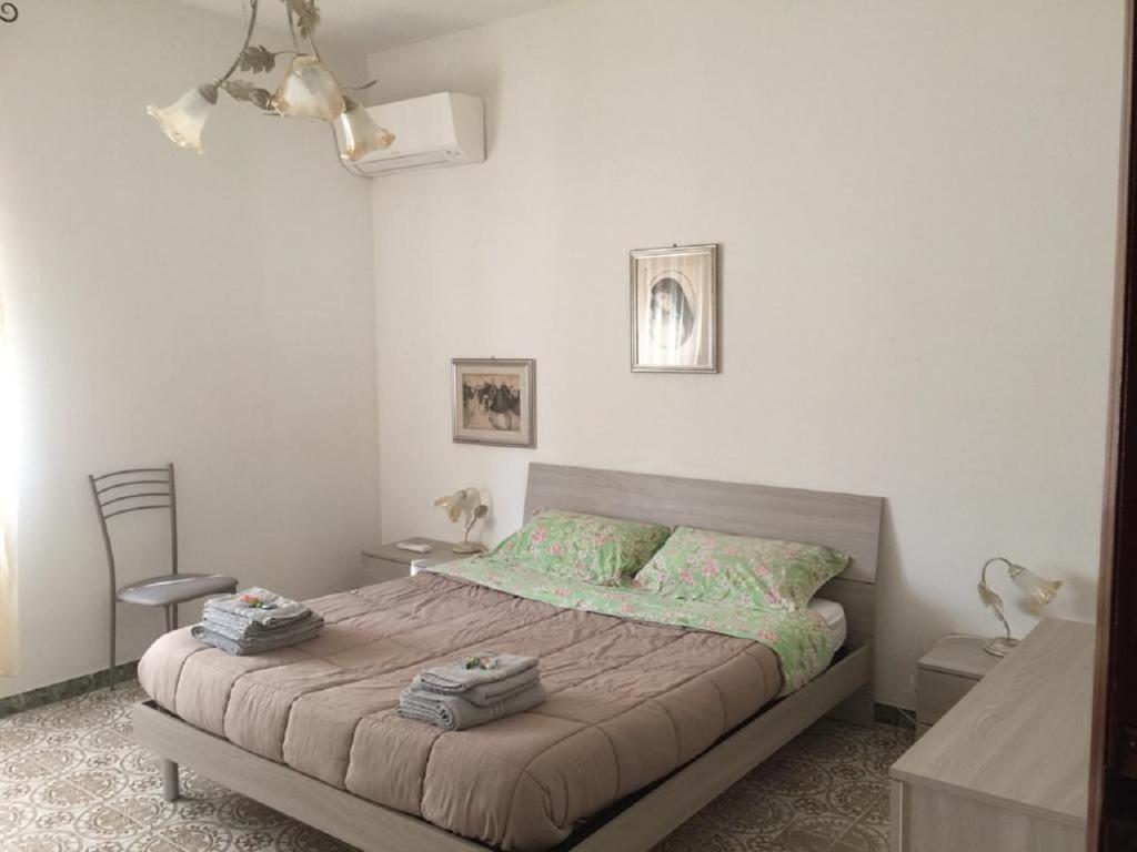 a bedroom with a bed and a chair in it at Casa Pierina in Alghero