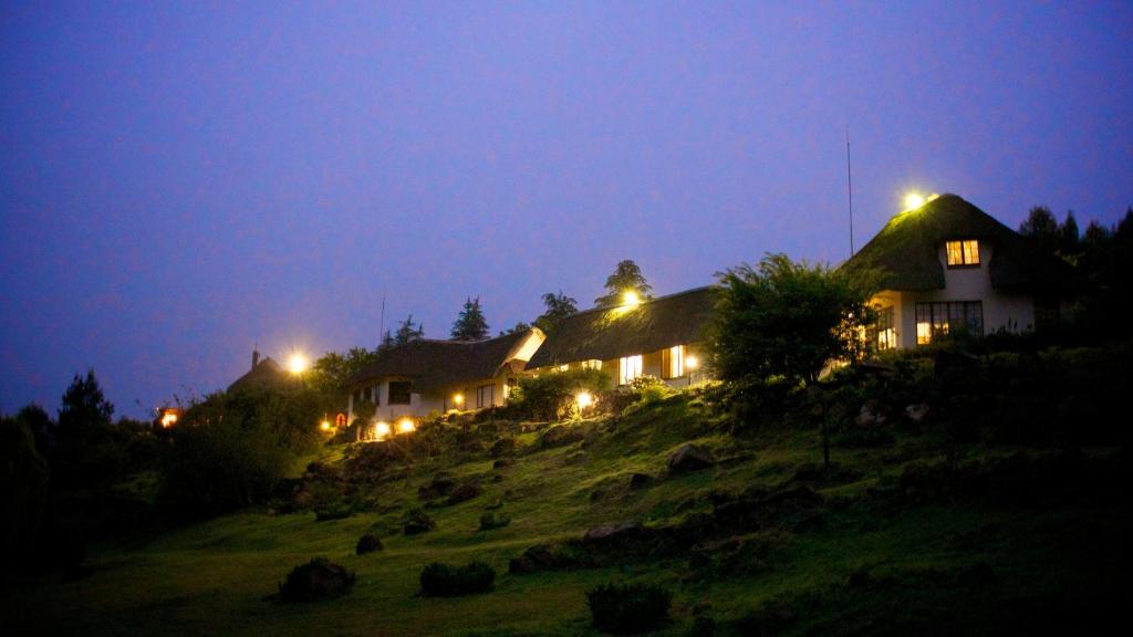 una casa en la cima de una colina por la noche en Hawklee Country House, en Fort Nottingham