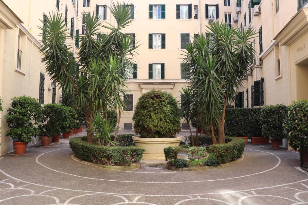 einen Innenhof mit Palmen vor einem Gebäude in der Unterkunft The Center Of Rome B&B in Rom