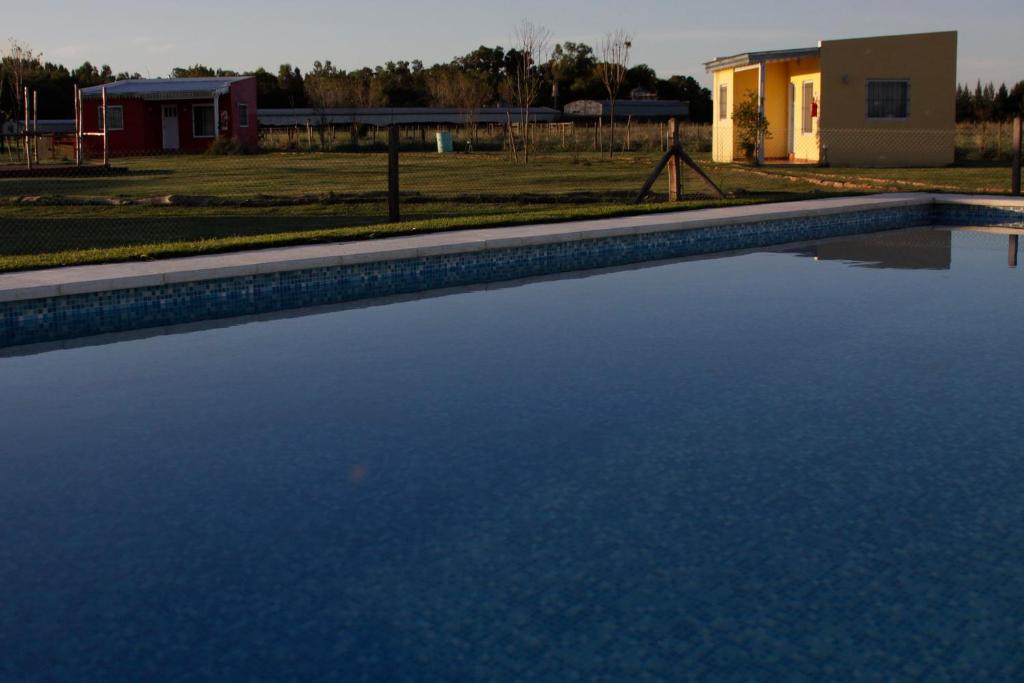 una piscina de agua frente a una casa en La Chakana de Uribelarrea en Uribelarrea