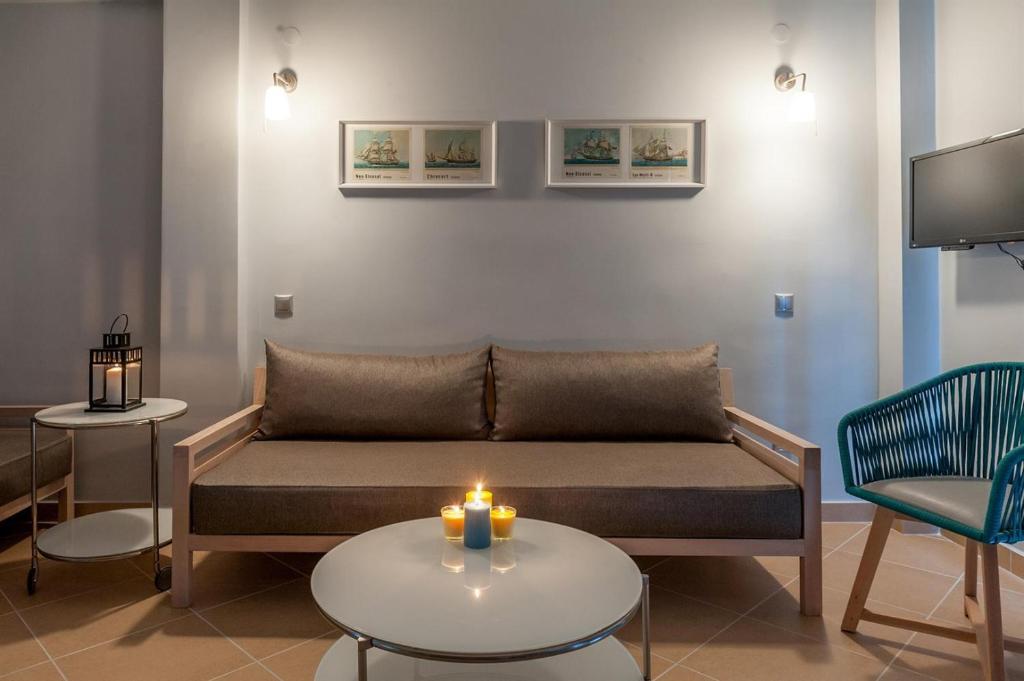 sala de estar con sofá y mesa con velas en Villa Despina Green Suites, en Polychrono