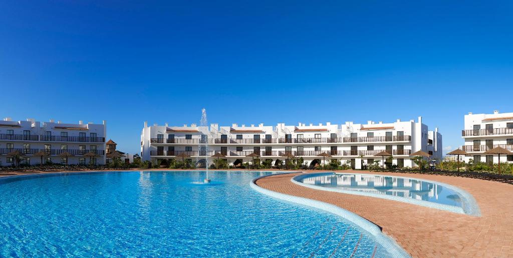 a swimming pool with buildings in the background at Sol Dunas - All Inclusive in Santa Maria