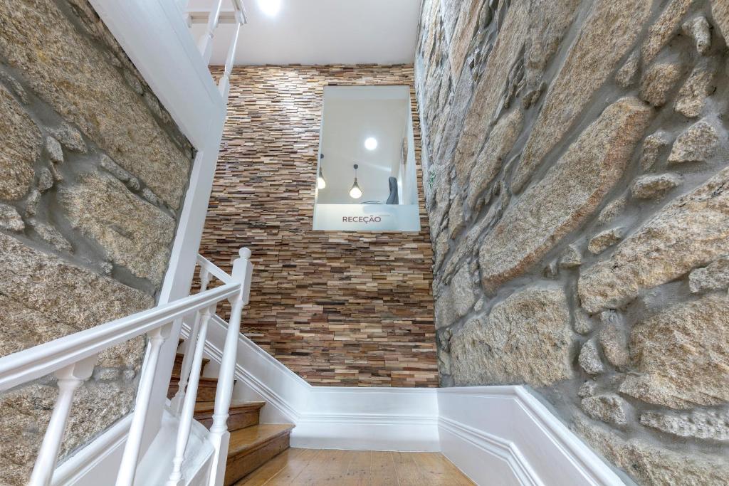 a staircase with a stone wall and a mirror at São Francisco in Matosinhos