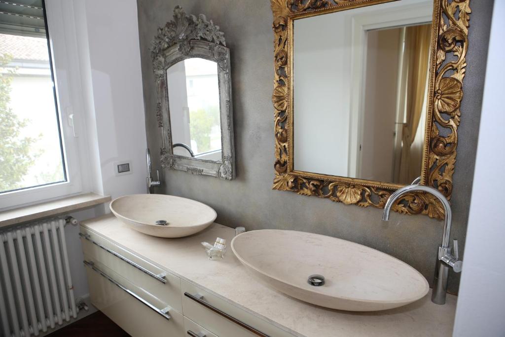 uma casa de banho com dois lavatórios e um espelho na parede em Champagne Rooms em Sirmione