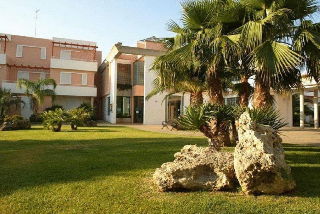 a statue of a palm tree in front of a building at Tramonti Residence in Sant'Isidoro