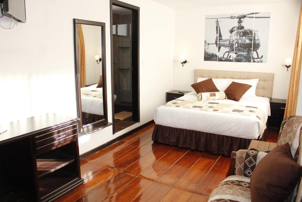 a bedroom with a bed and a mirror at Air Suites Hotel Boutique in Quito